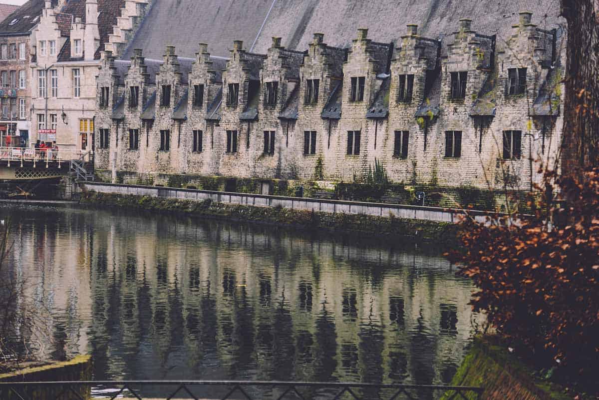 Historic riverside houses in Ghent reflecting on the water