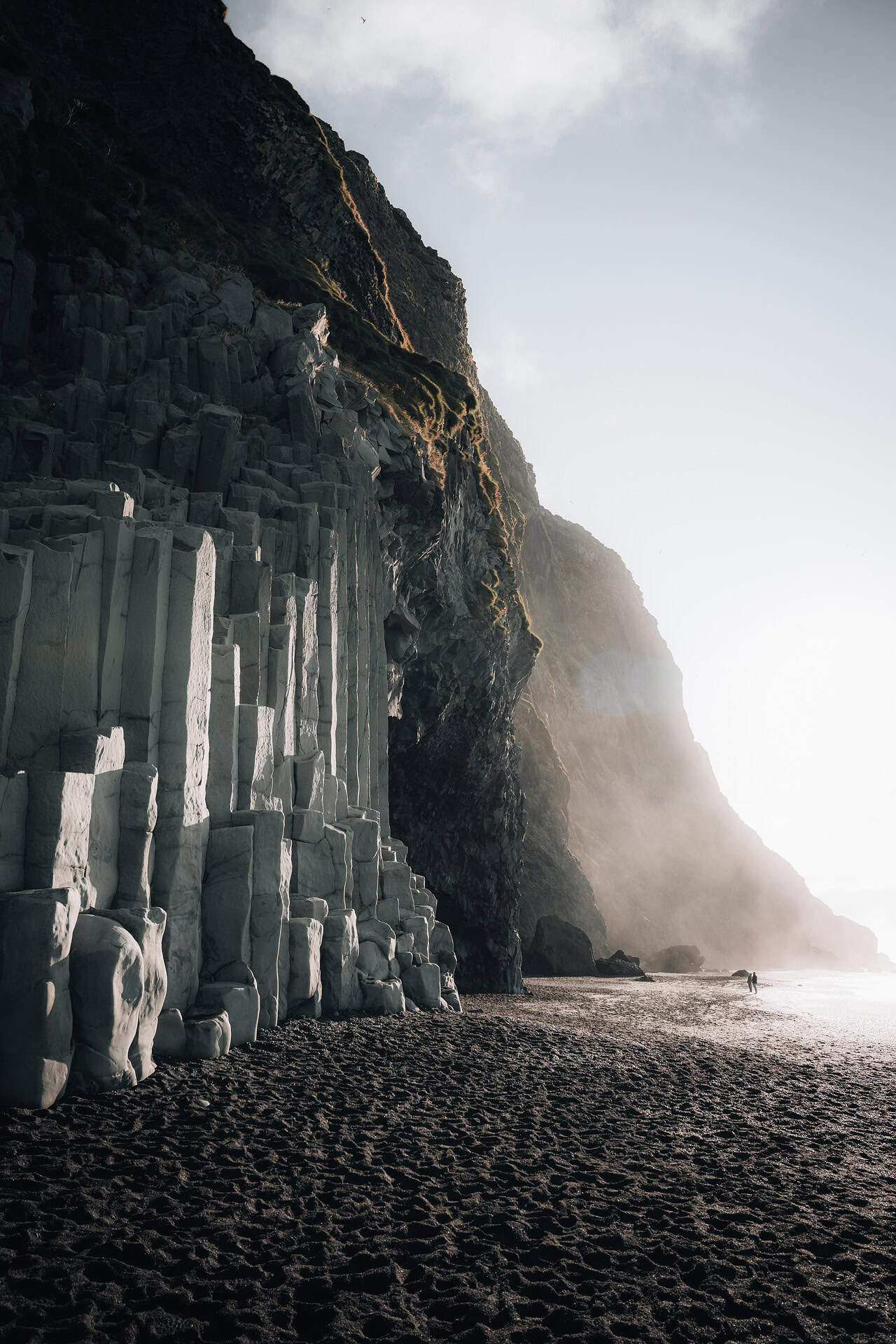 Empty beach with straw umbrellas, suggesting a tranquil winter European getaway.
