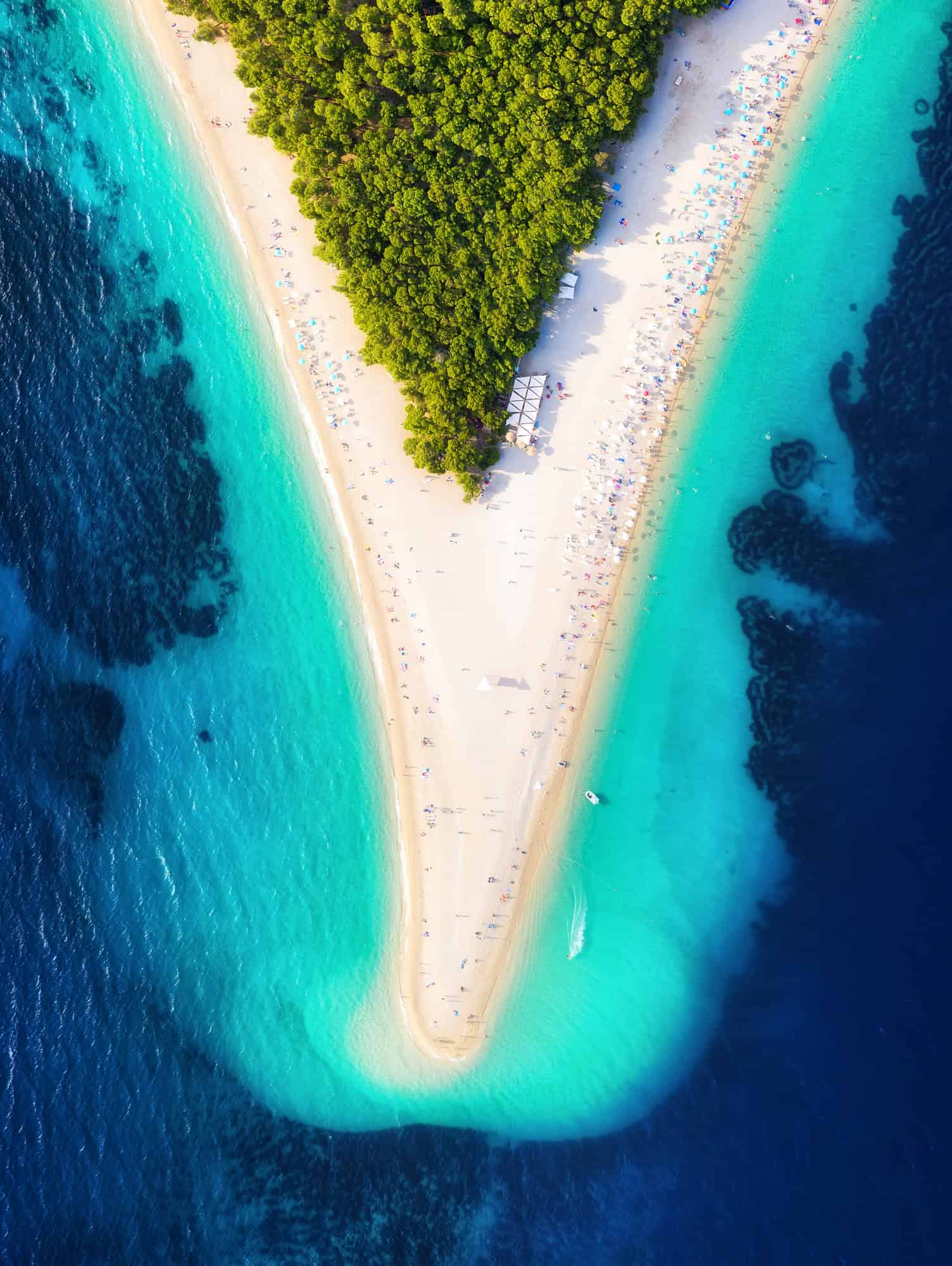 Empty beach with straw umbrellas, suggesting a tranquil winter European getaway.