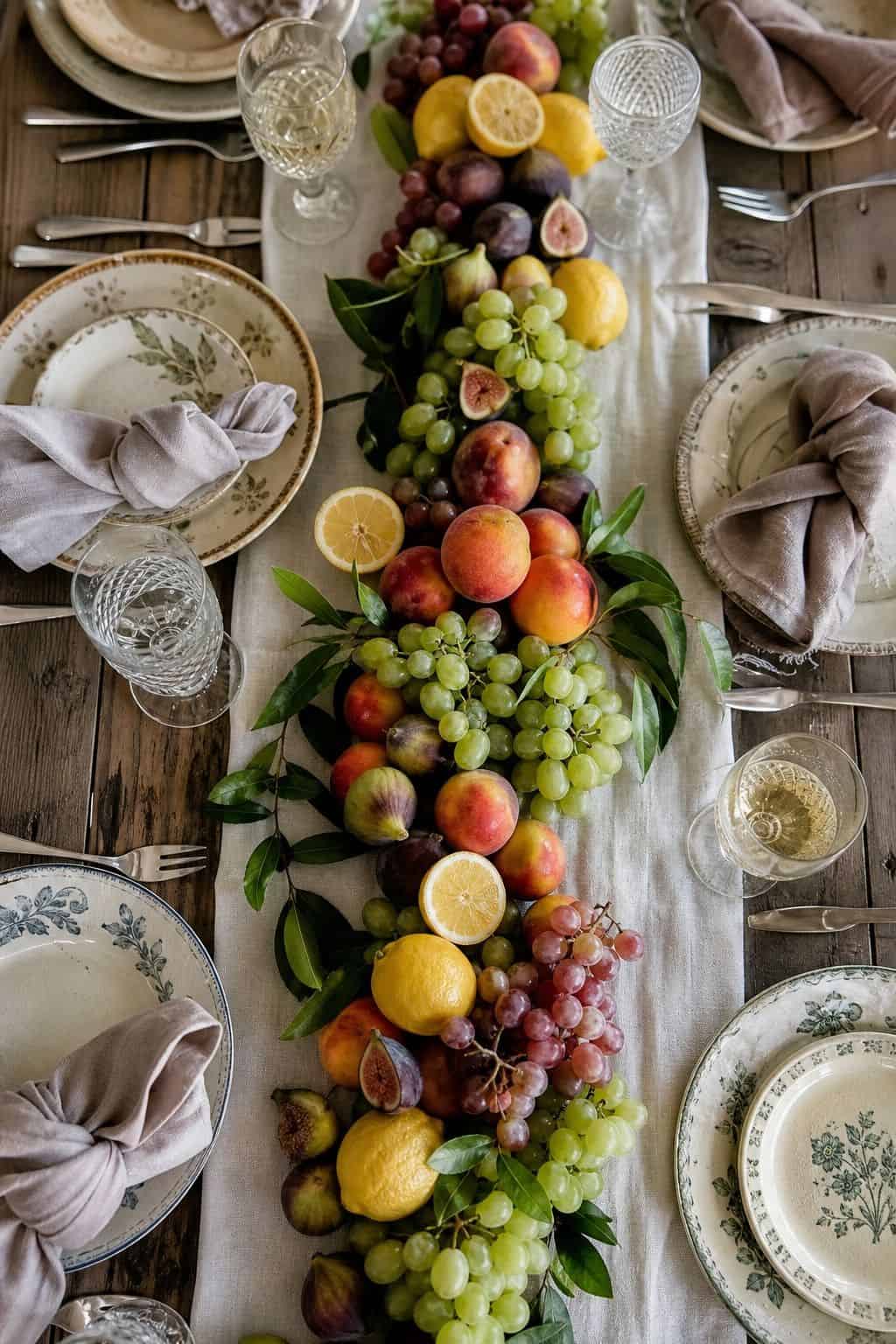 Summer table setting with fresh fruit arranged down the center of the table.