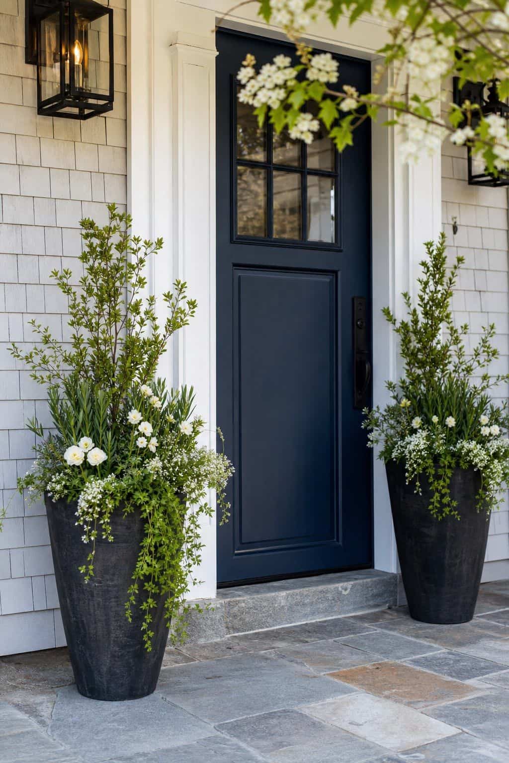 Tall Planters by the Door shown as a realistic Pretty Wild World image for 18 Front Porch Spring Decor Ideas With Fresh Curb Appeal.