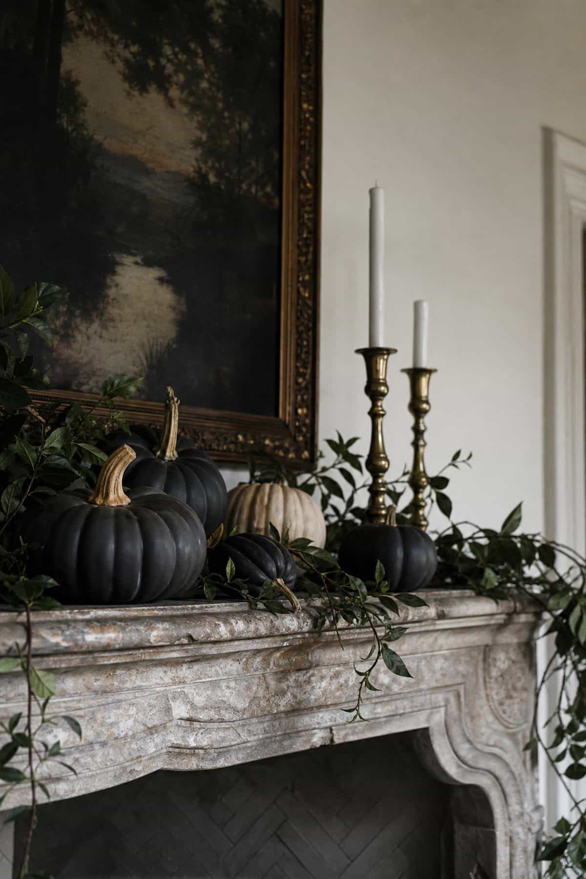 Matte black pumpkins arranged on a refined Halloween fireplace mantel
