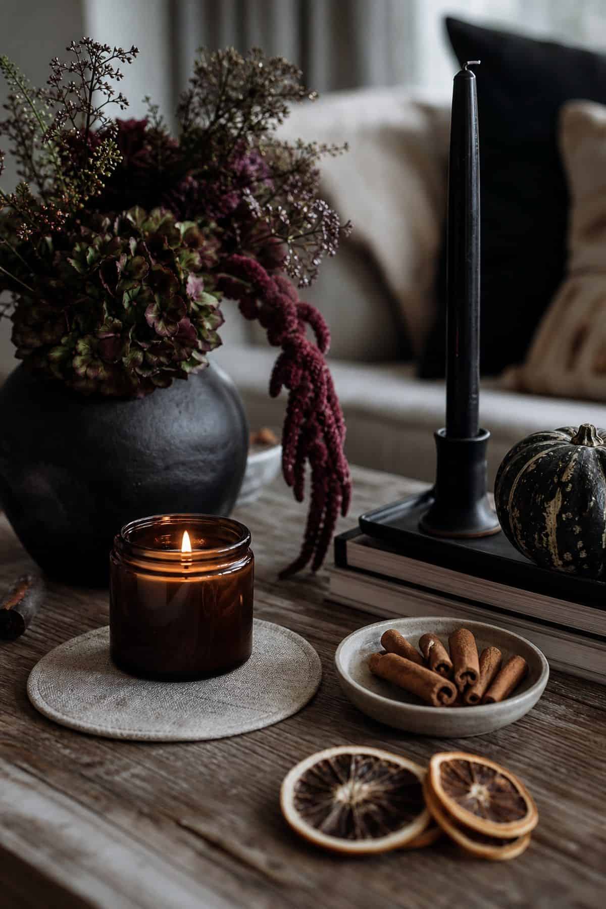 Subtle Halloween scent vignette with an amber candle, spices, and dark florals