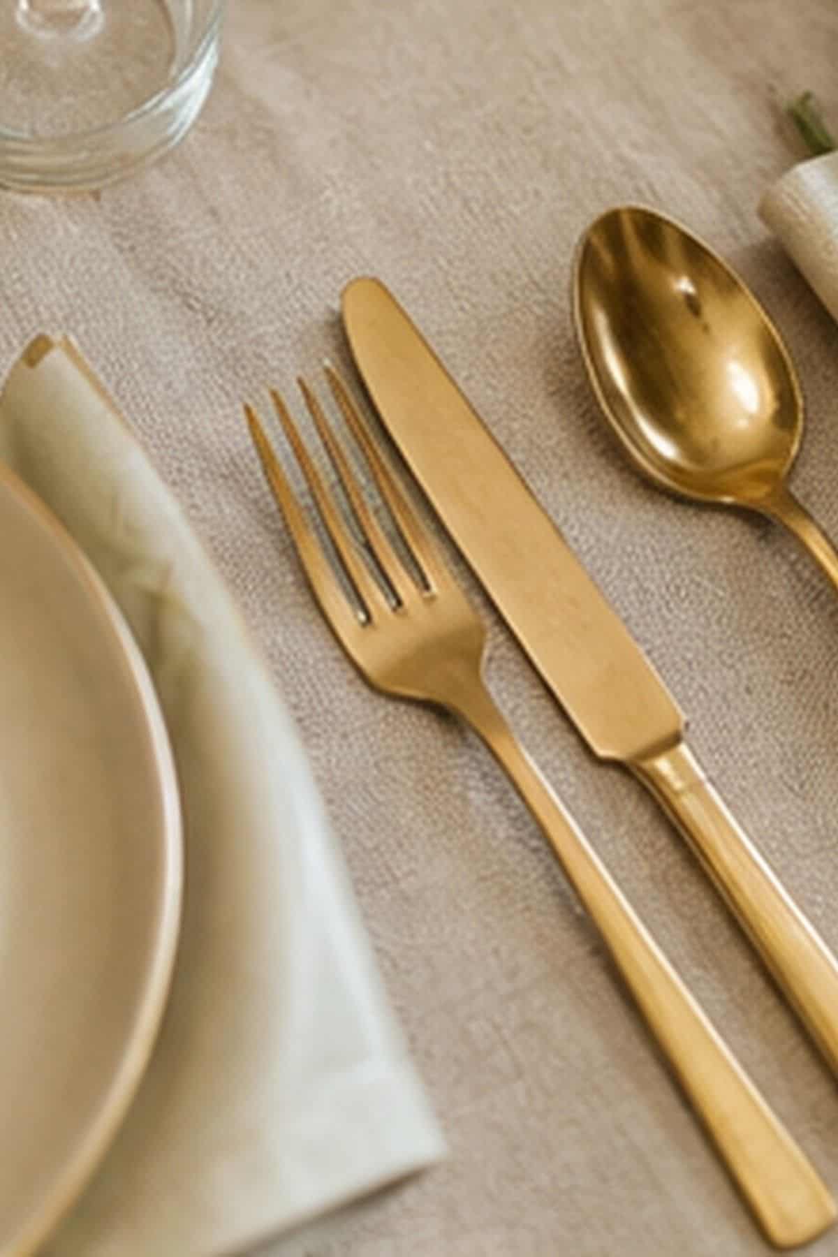 Gold Flatware Warmth shown as a realistic Pretty Wild World image for 18 Thanksgiving Table Setting Ideas That Feel Warm and Effortless.