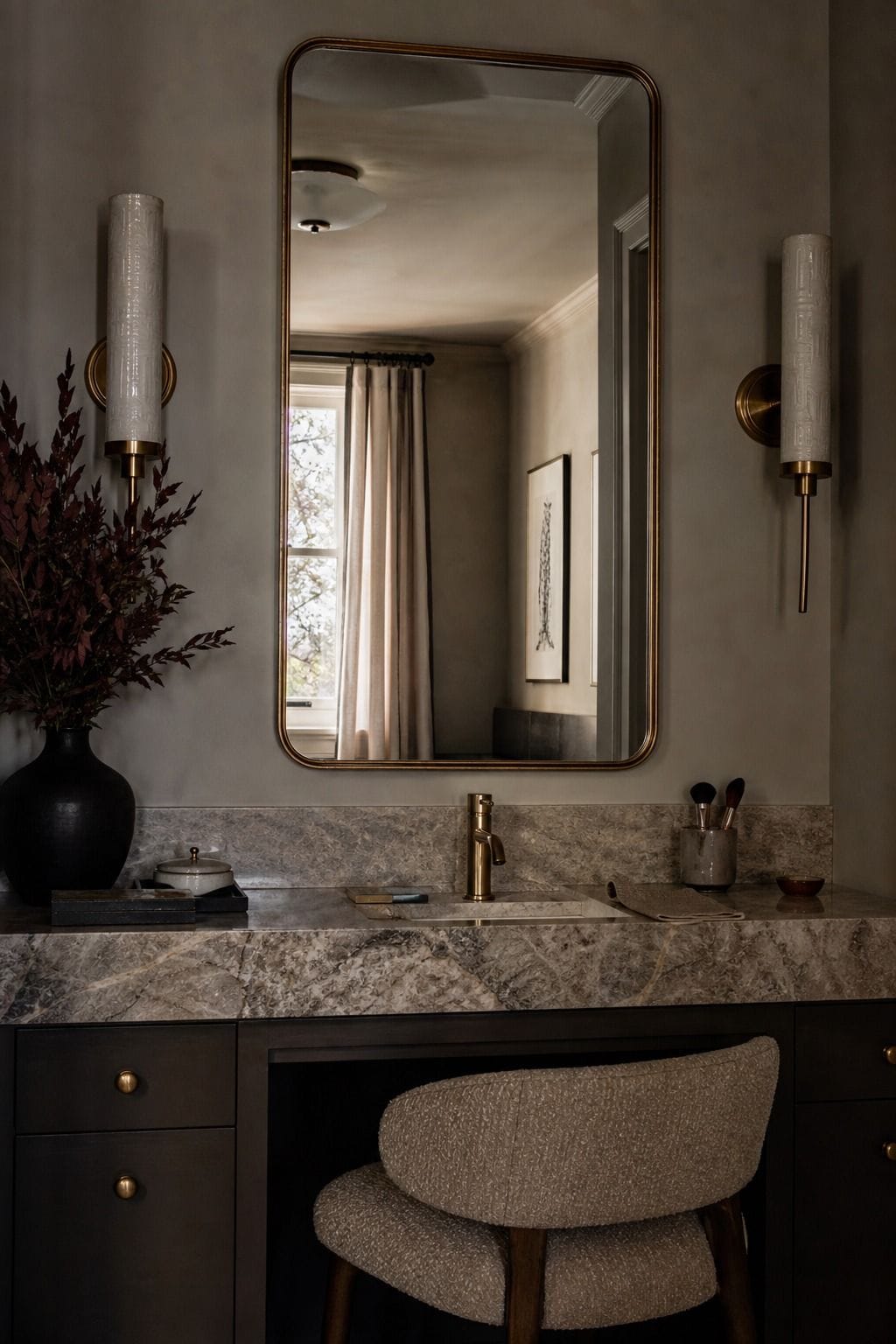 Pair of brass sconces framing a bathroom vanity mirror above a makeup counter