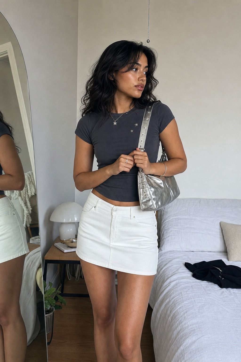 White Mini Skirt with a Silver Shoulder Bag shown as a realistic Pretty Wild World image for 17 Stargirl Outfit Ideas That Bring the Y2K Celestial Aesthetic to Life.