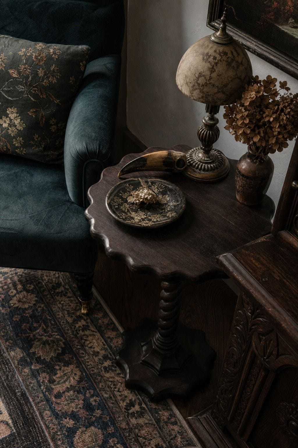 Small scalloped side table beside a velvet chair in a whimsigoth corner.
