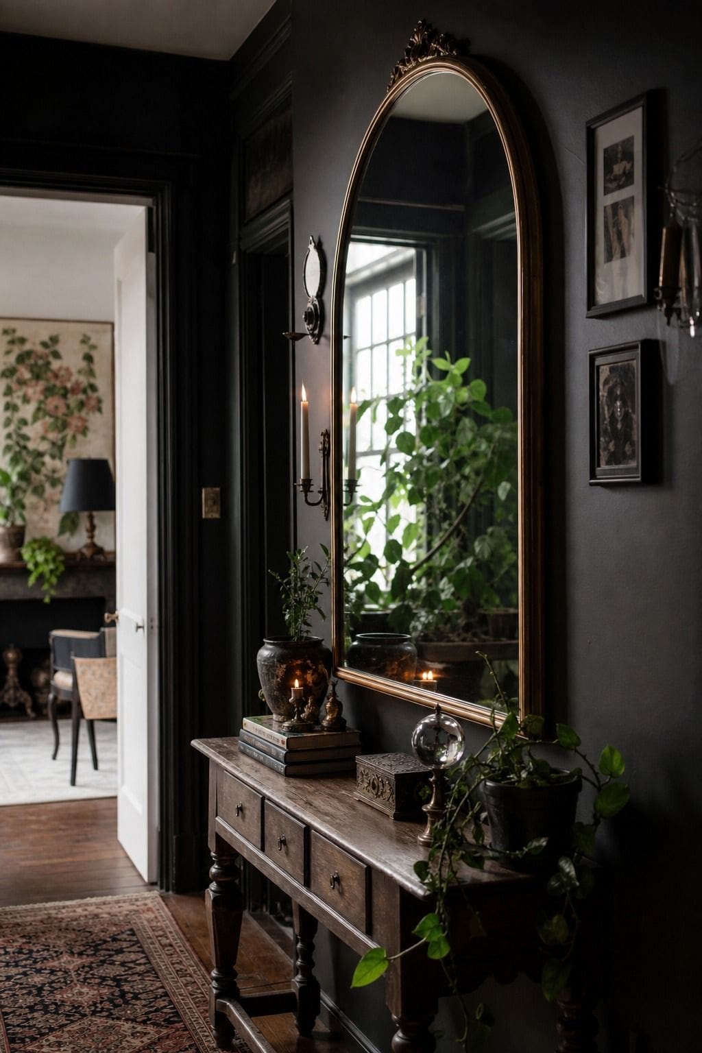 Tall arched mirror on a charcoal hallway wall with plants, candles, and vintage accents.