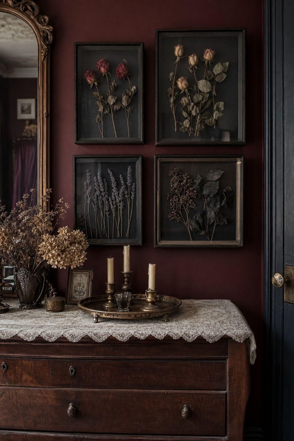 Burgundy bedroom wall with shadow-box frames of dried roses, lavender, and dark foliage.