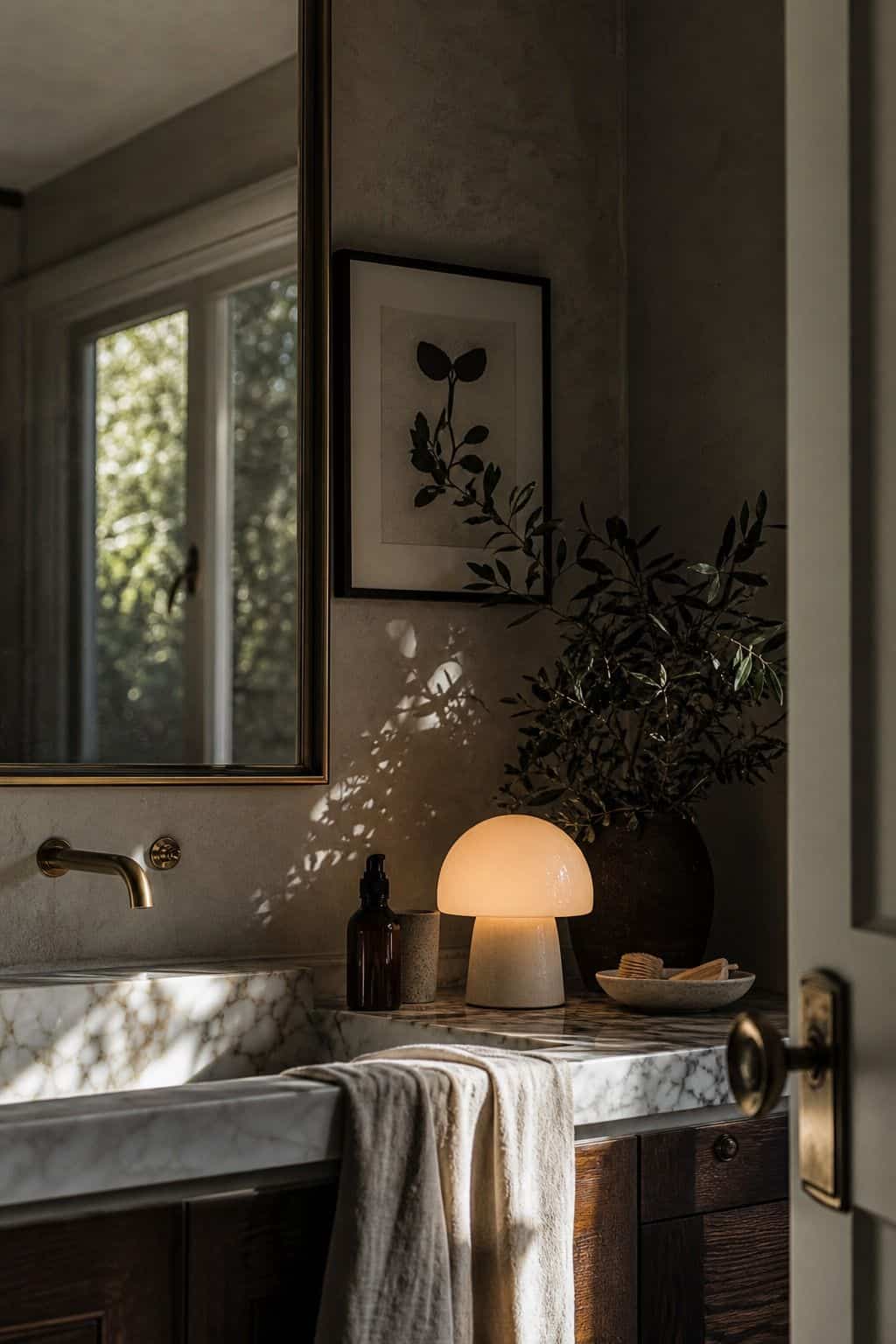 Editorial vertical photo for Pretty Wild World showing a small mushroom or frosted globe lamp on a vanity, adding cozy 1970s atmosphere without harsh lighting. The scene illustrates A Mushroom or Globe Lamp as part of a 70s bathroom decor ideas guide, with warm retro color, natural daylight, realistic lived-in styling, textured materials, and a polished but attainable home look. Designed to inspire readers who want vintage bathroom charm without making the room feel dated or overly themed.
