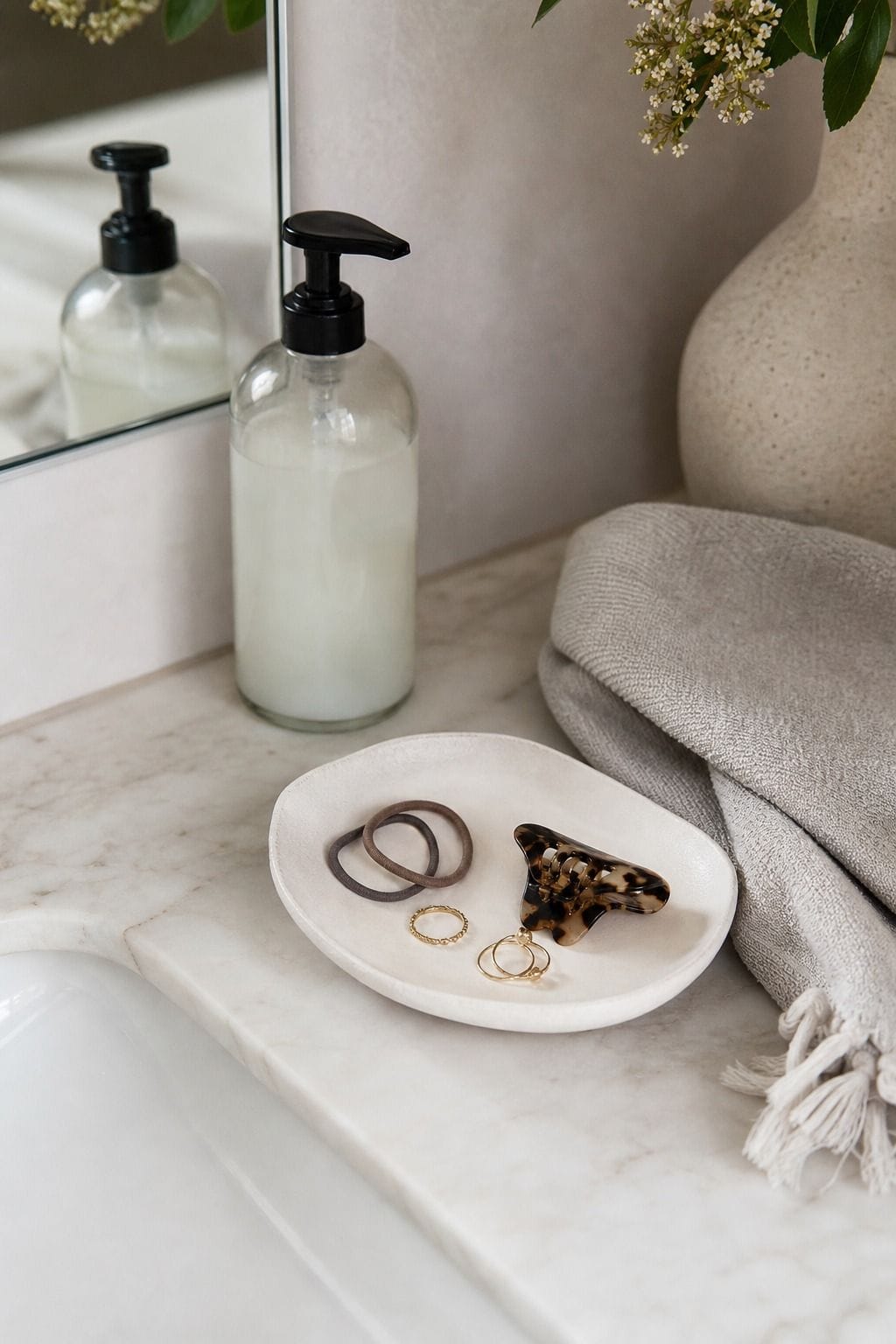 Keep Jewelry or Hair Ties in a Decorative Dish shown as a realistic Pretty Wild World image for 15 Bathroom Counter Decor Ideas for a Fresh, Spa-Like Bathroom.