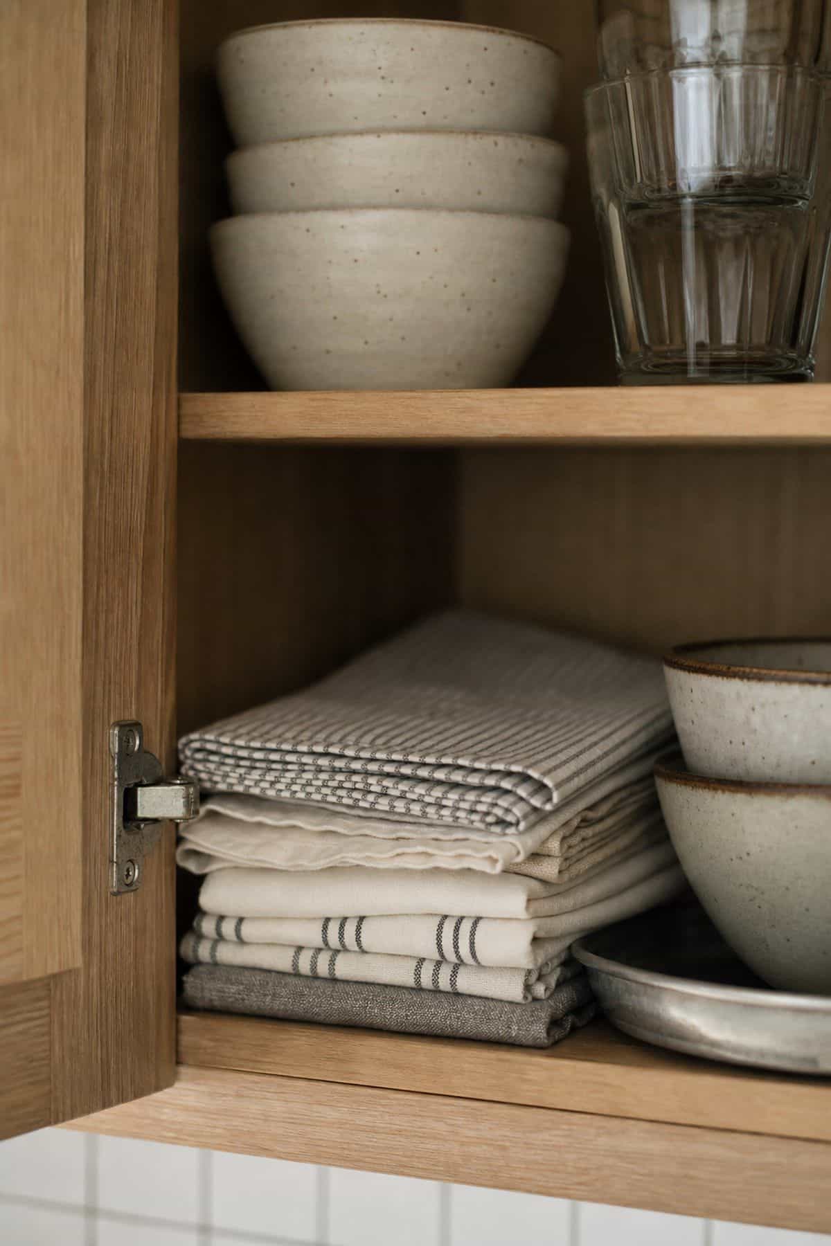 Stack Everyday Dishes for Fast Access shown as a realistic Pretty Wild World image for 15 Breakfast Counter in Kitchen Ideas for a Warm, Beautifully Styled Kitchen.
