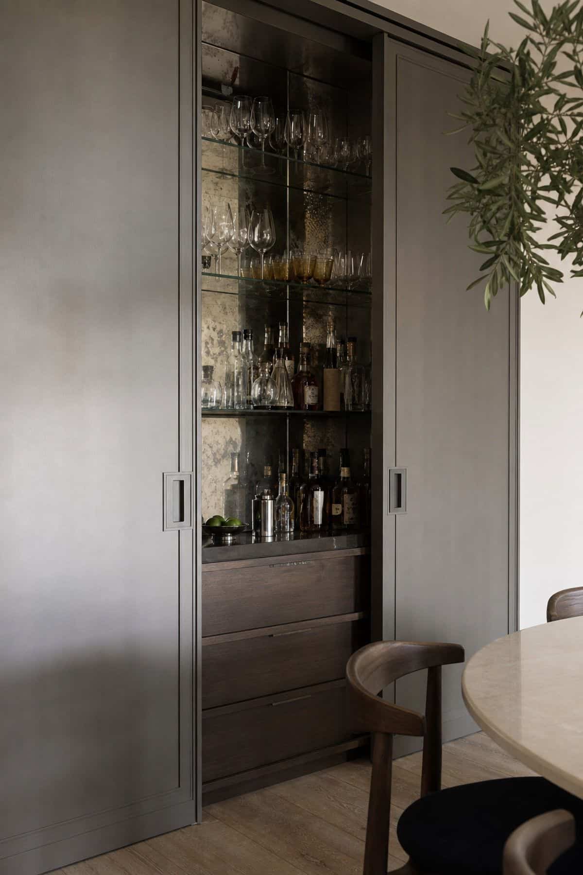 Built-In Bar Area Masked by Sliding Doors shown as a realistic Pretty Wild World image for 15 Hidden Bar Ideas for Home for a More Curated Home Aesthetic.