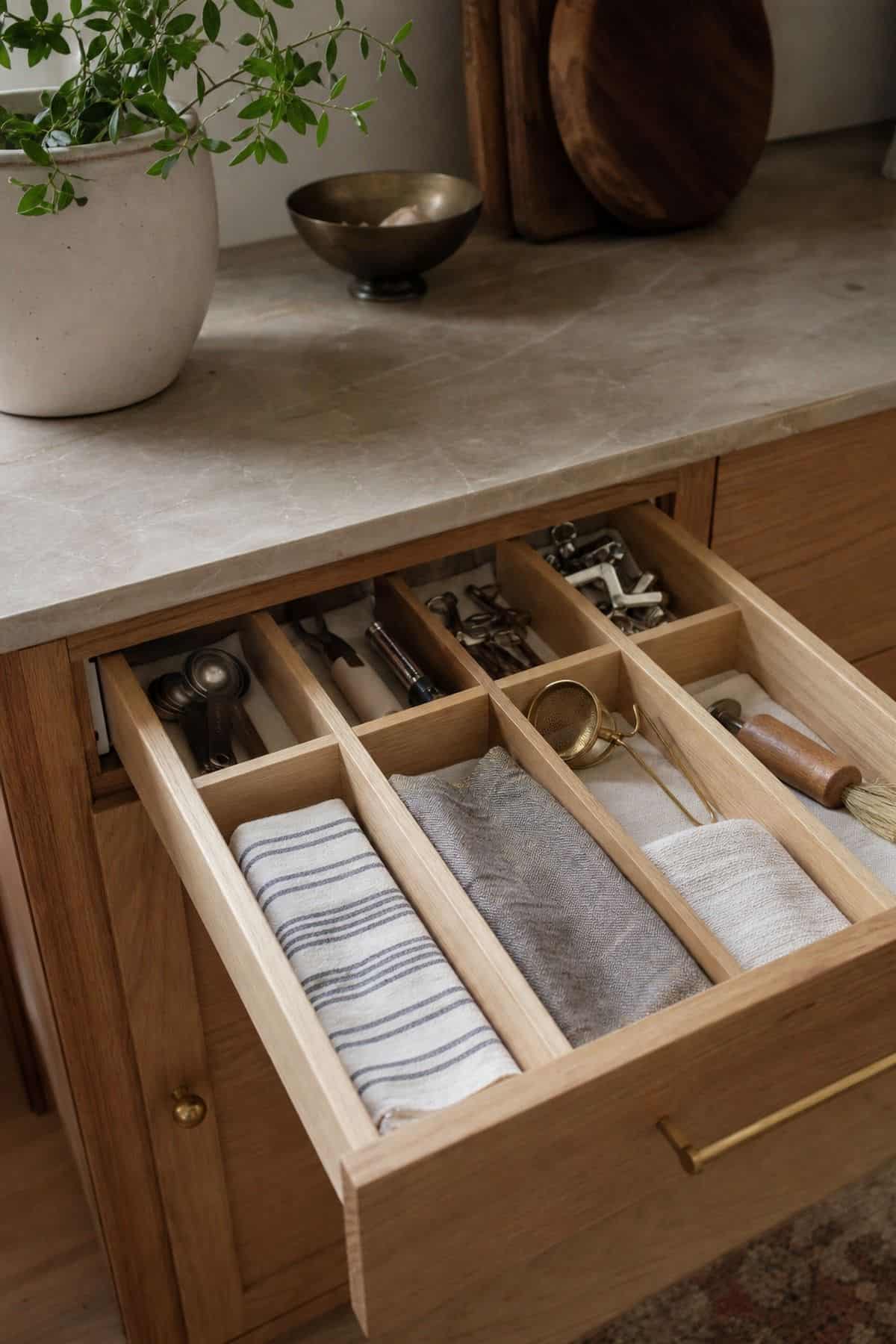 Insert Dividers in Shallow Drawers for Small Tools shown as a realistic Pretty Wild World image for 15 Kitchen Counter Organization Ideas for a Warm, Beautifully Styled Kitchen.