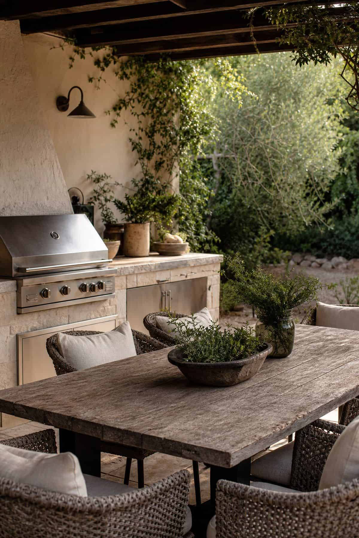 Choose a rustic wooden table paired with comfortable seating shown as a realistic Pretty Wild World image for 15 Outdoor Kitchen Patio Decor Ideas for a Warm, Beautifully Styled Kitchen.