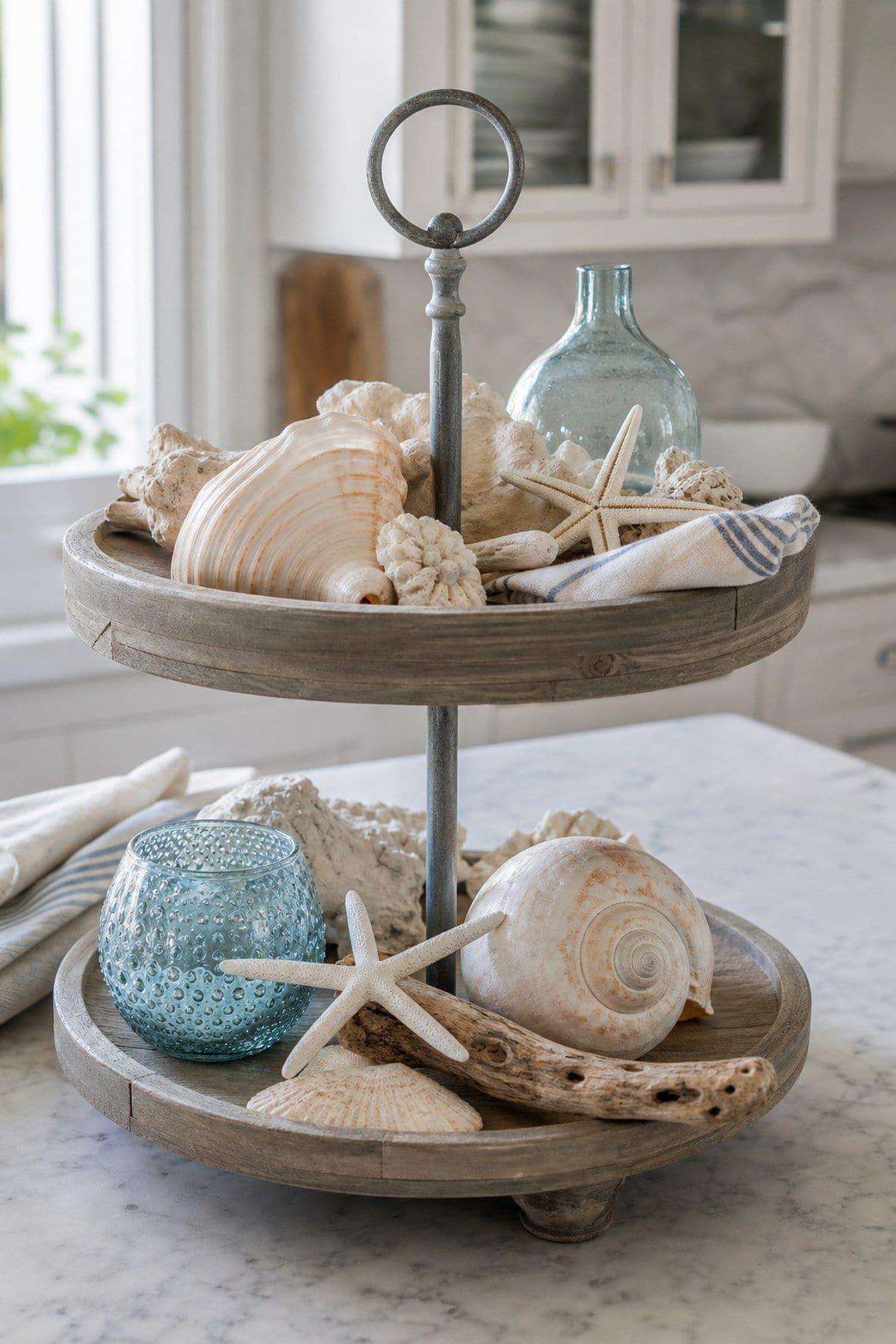 Showcase Seashells and Starfish for a Coastal Feel shown as a realistic Pretty Wild World image for 15 Summer Tiered Tray Decor Ideas for a Collected, Seasonal Home Aesthetic.