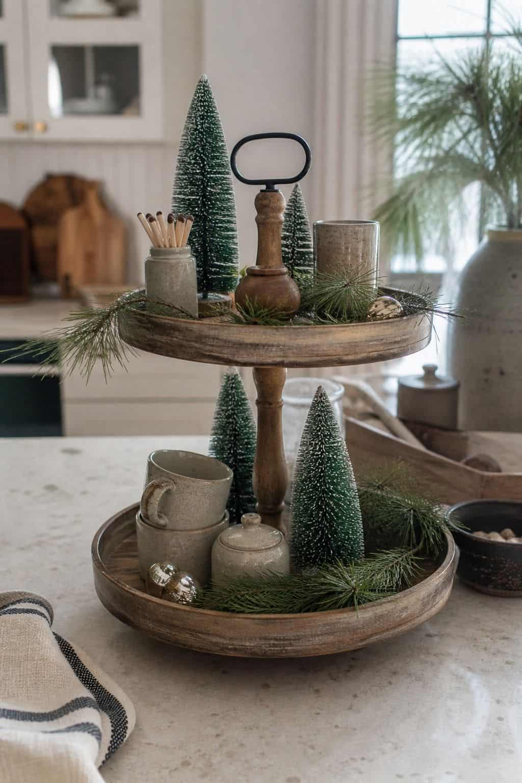 Feature tiny evergreen trees and sprigs of pine shown as a realistic Pretty Wild World image for 15 Winter Tiered Tray Ideas for a Collected, Seasonal Home Aesthetic.