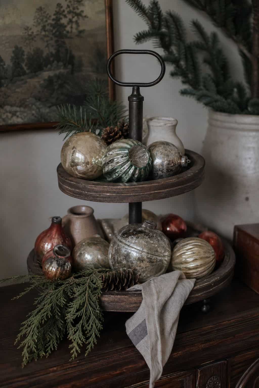 Feature vintage holiday baubles and ornaments shown as a realistic Pretty Wild World image for 15 Winter Tiered Tray Ideas for a Collected, Seasonal Home Aesthetic.