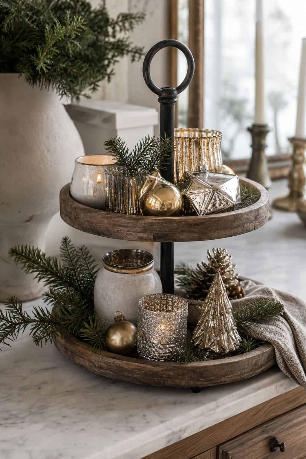 Use metallic touches in gold or silver for sparkle shown as a realistic Pretty Wild World image for 15 Winter Tiered Tray Ideas for a Collected, Seasonal Home Aesthetic.